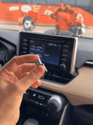 Wireless Car Play adapter by My Store connected to a car's dashboard display, enabling seamless smartphone integration.
